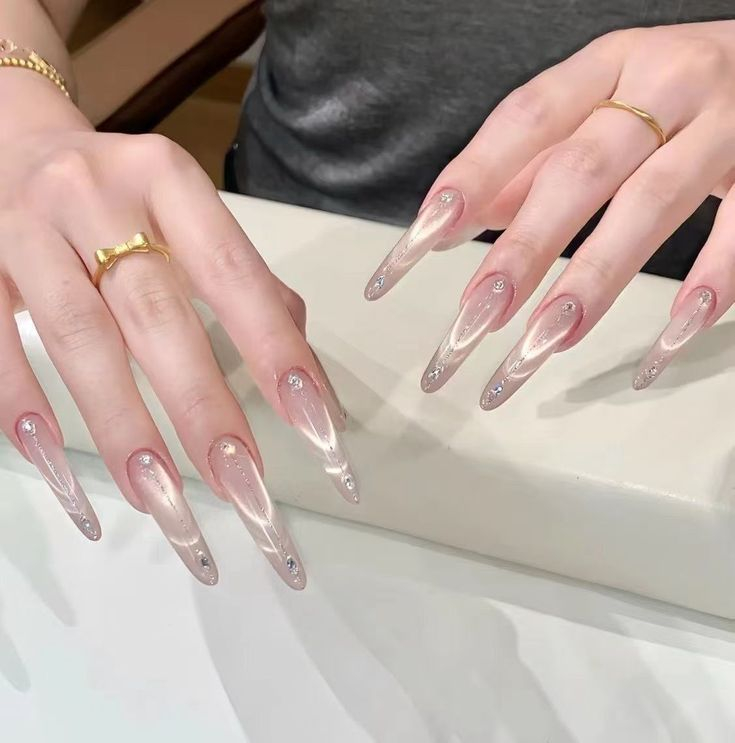 Long stiletto sheer pink cat eye nails with delicate rhinestone line accents