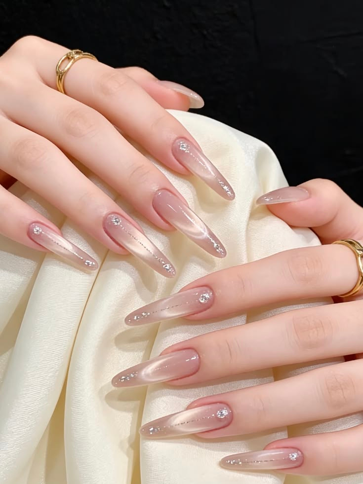 Glossy pink velvet cat eye stiletto nails with subtle crystal embellishments