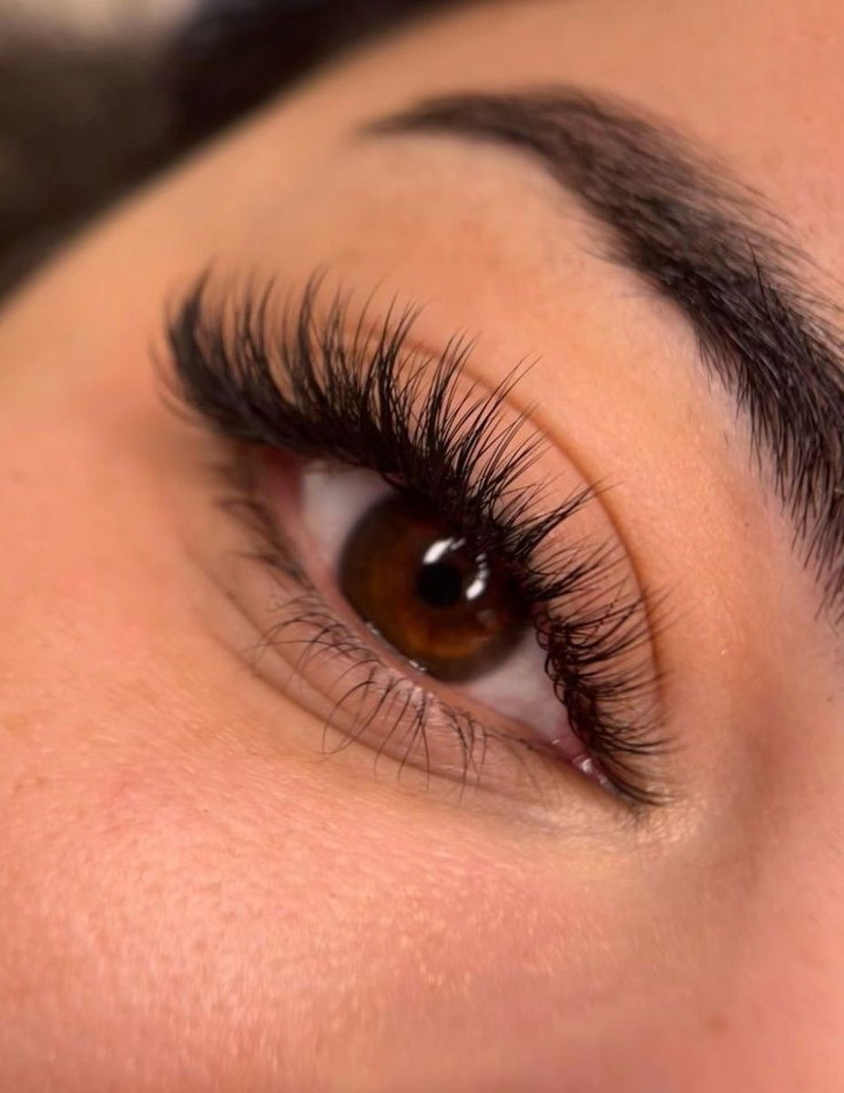Full volume eyelash extensions with dramatic curl on brown eyes