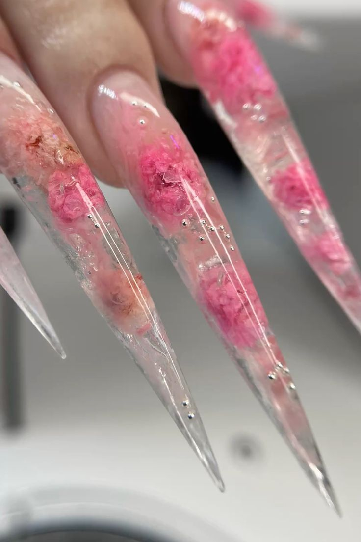 Clear stiletto nails with encapsulated dried pink blossoms and micro silver beads