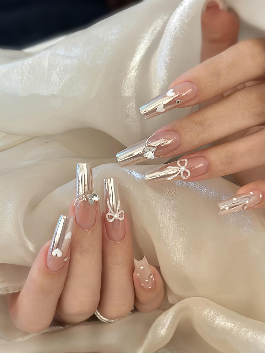 Glossy liquid silver chrome nails Sherway Gardens Mall on long square tips with delicate white ribbon charms