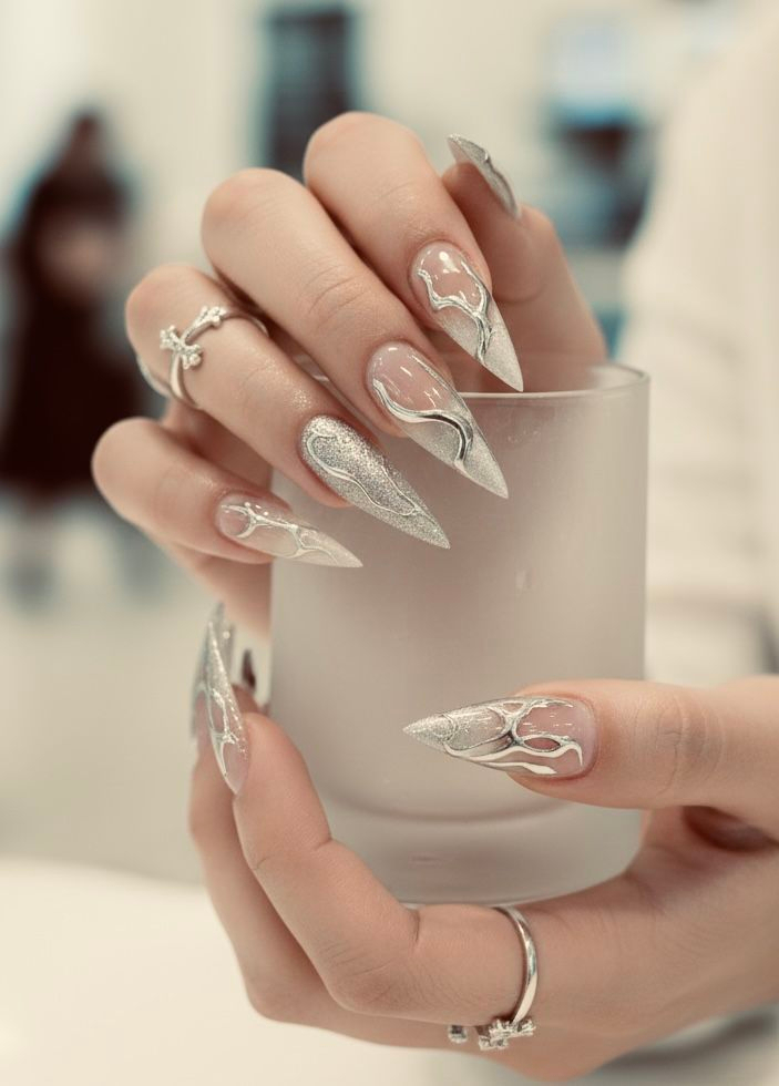 Futuristic stiletto chrome nails Sherway Gardens Mall with silver shimmer and 3D metallic liquid swirl accents